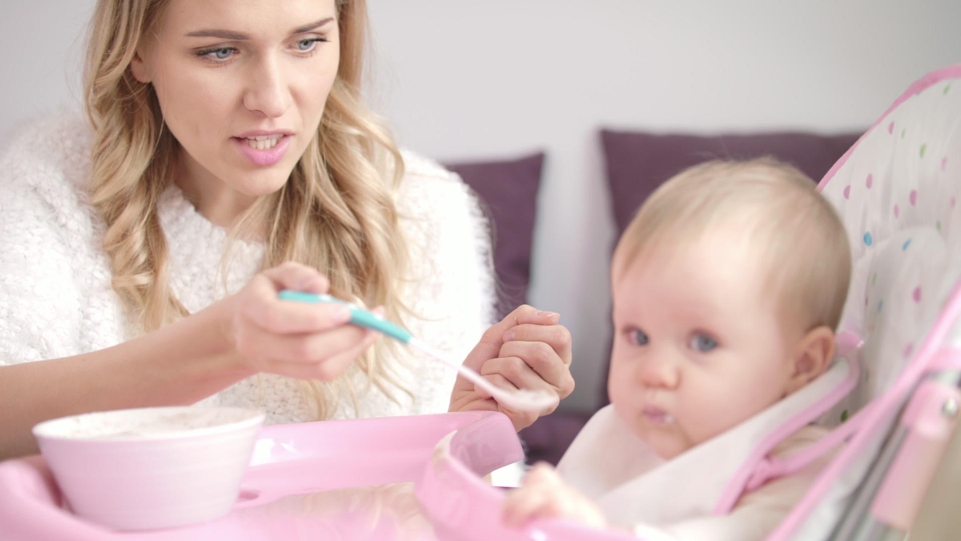 金发女人用勺子喂养孩子的母亲用纯食喂养婴儿视频的预览图