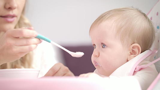婴儿用勺子吃纯婴儿妈妈用粥喂孩子视频的预览图