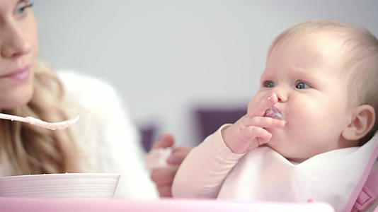 母亲喂养婴儿不满意的孩子吃纯食品第一次喂养婴儿视频的预览图