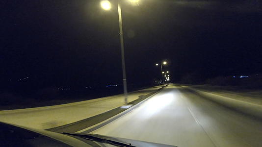 司机晚上在空大道上开车用前灯点亮原始灯视频的预览图