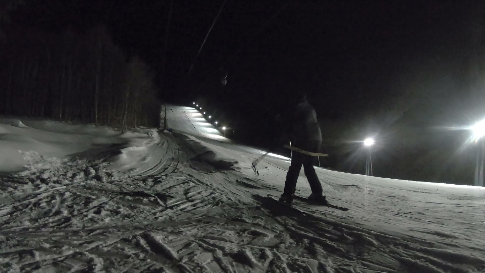 滑雪电梯把一个人拉上山坡在明亮的斜坡上滑雪视频的预览图
