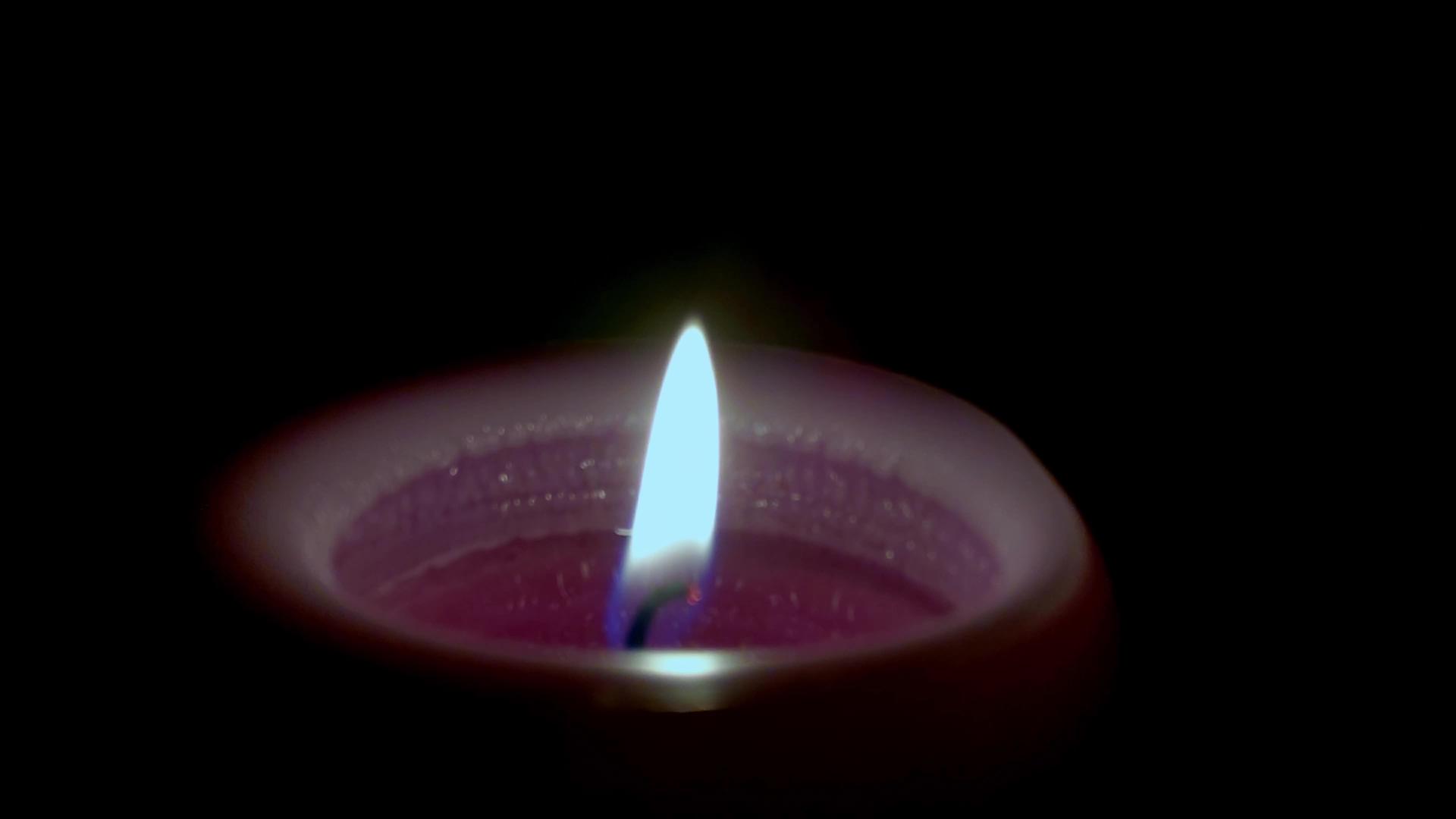 关闭在黑暗中燃烧的蜡烛以纪念受害者视频的预览图