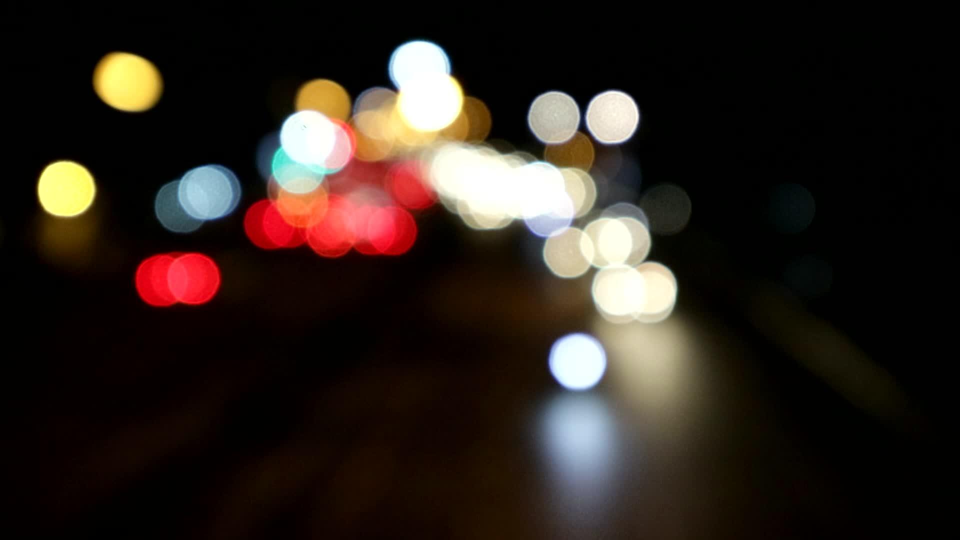 绿色交通灯后的模糊车辆灯视频的预览图