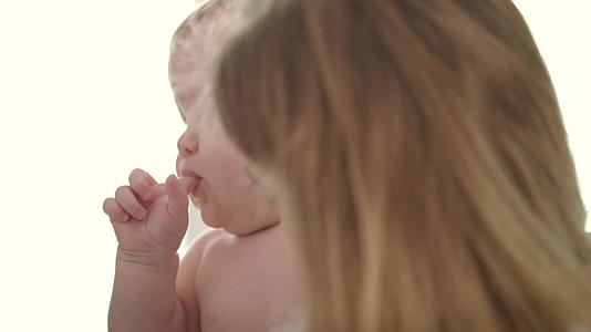 可爱的宝宝吃手指裸体的孩子用手指在妈妈嘴里视频的预览图