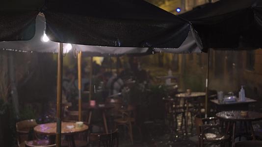 雨中的夜生活户外老城街咖啡馆的雨夜无法辨认视频的预览图