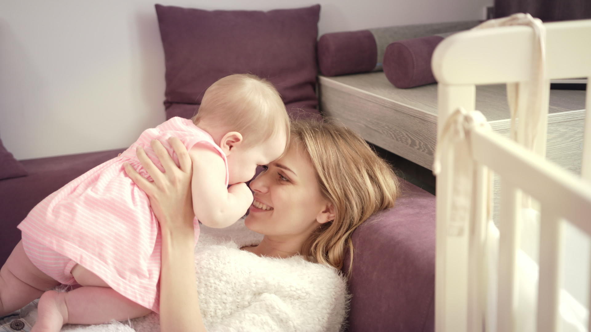 年轻的母亲在家亲吻婴儿来表达爱与幸福的概念视频的预览图