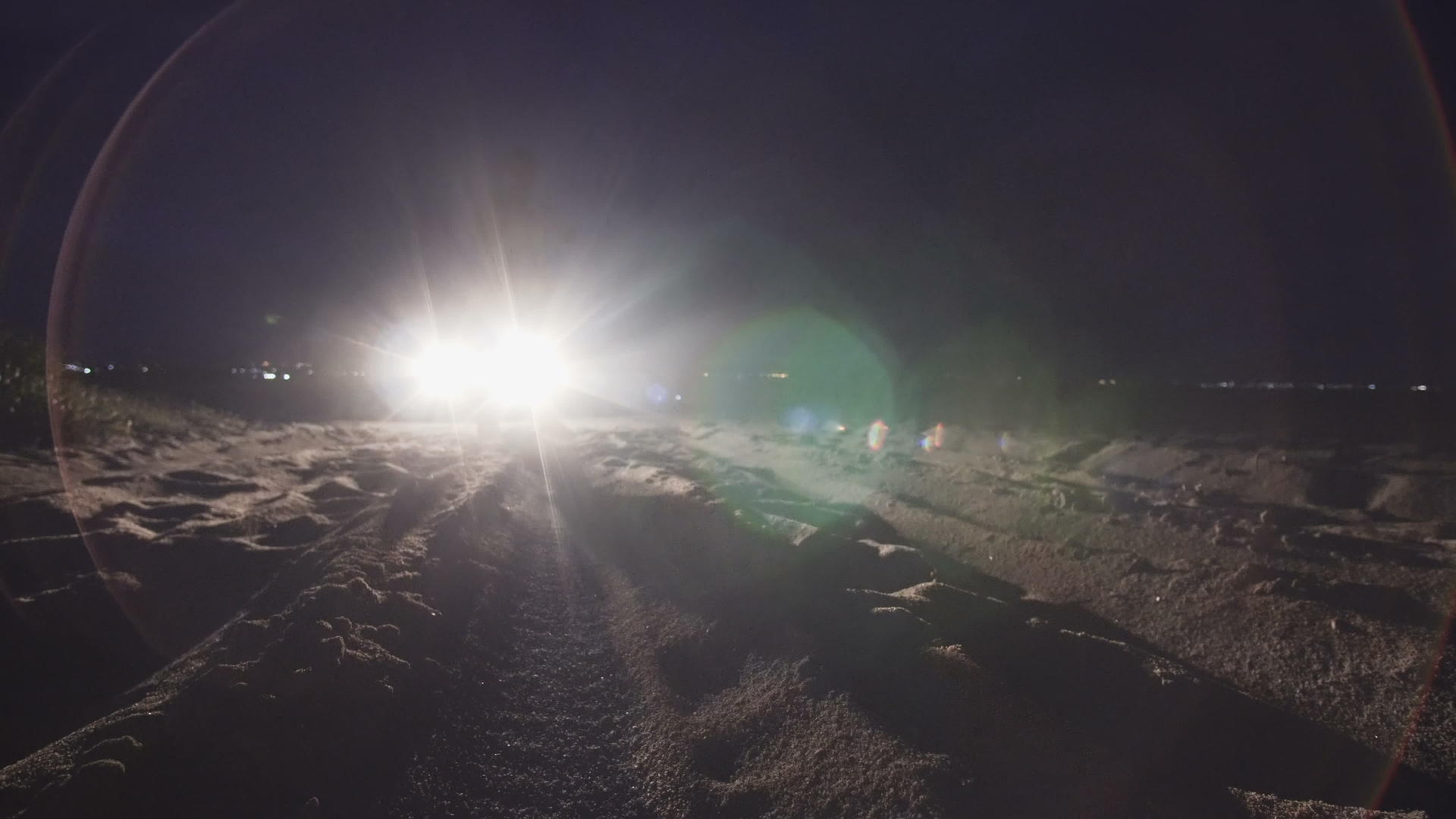 男人站在海滩上面对前灯的神秘和可怕的概念视频的预览图