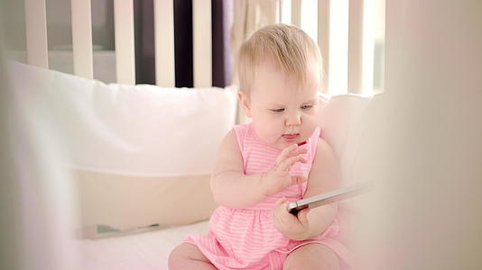 有智能手机的婴儿女持有智能手机视频的预览图