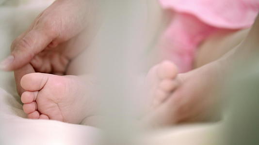母亲抚摸婴儿的脚家庭温柔的产妇护理视频的预览图