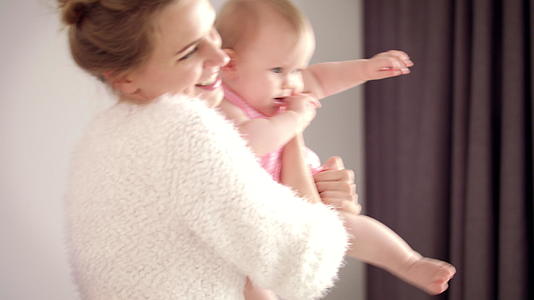宝妈抱着小宝逗她开心视频的预览图