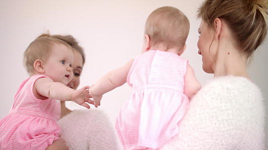 妈妈带着宝宝照镜子可爱的孩子玩镜视频的预览图