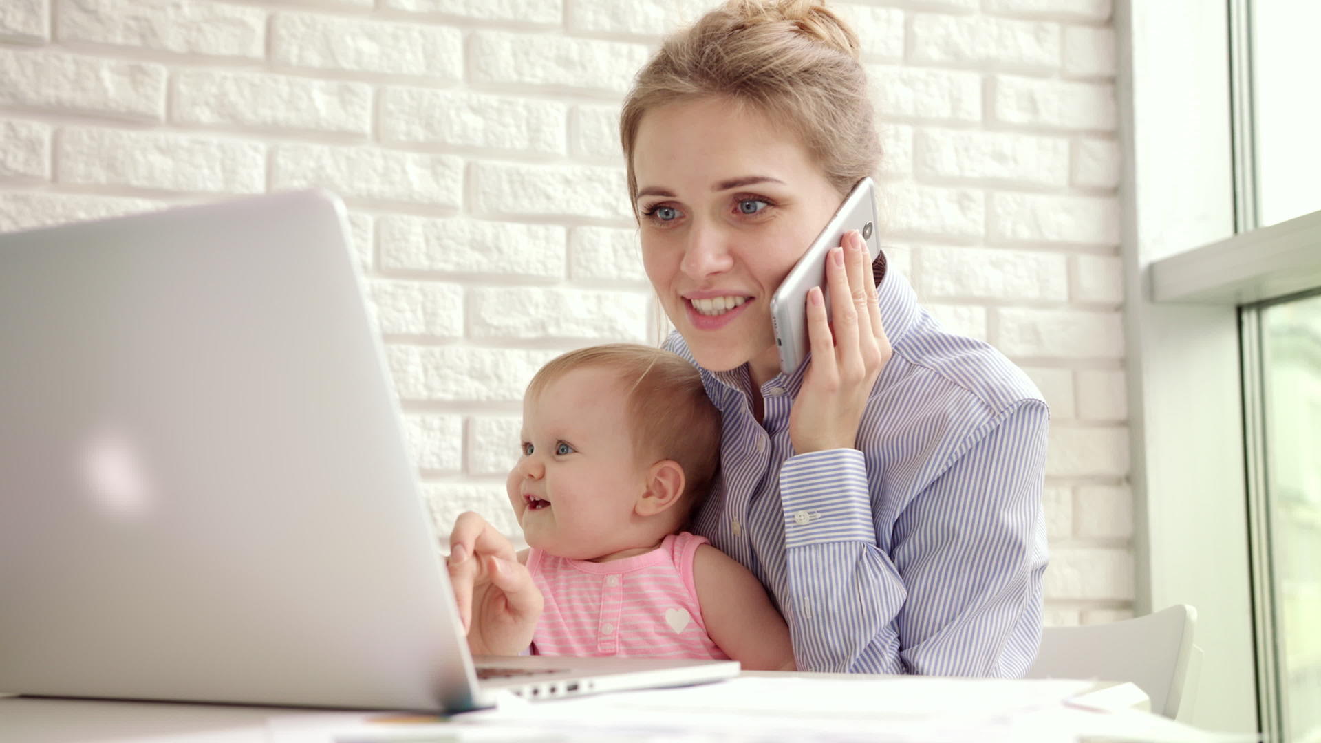 在家工作的商业妈妈带着孩子讲电话的笑女很开心视频的预览图