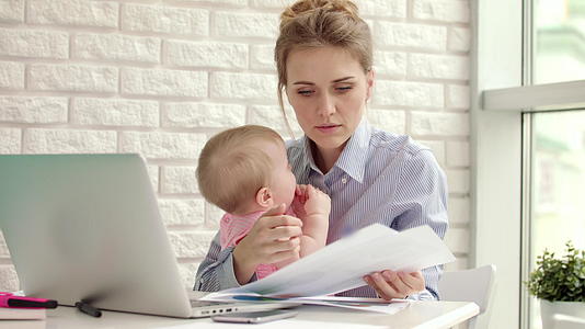 商业母亲在家和孩子一起工作母亲和孩子一起看文件视频的预览图