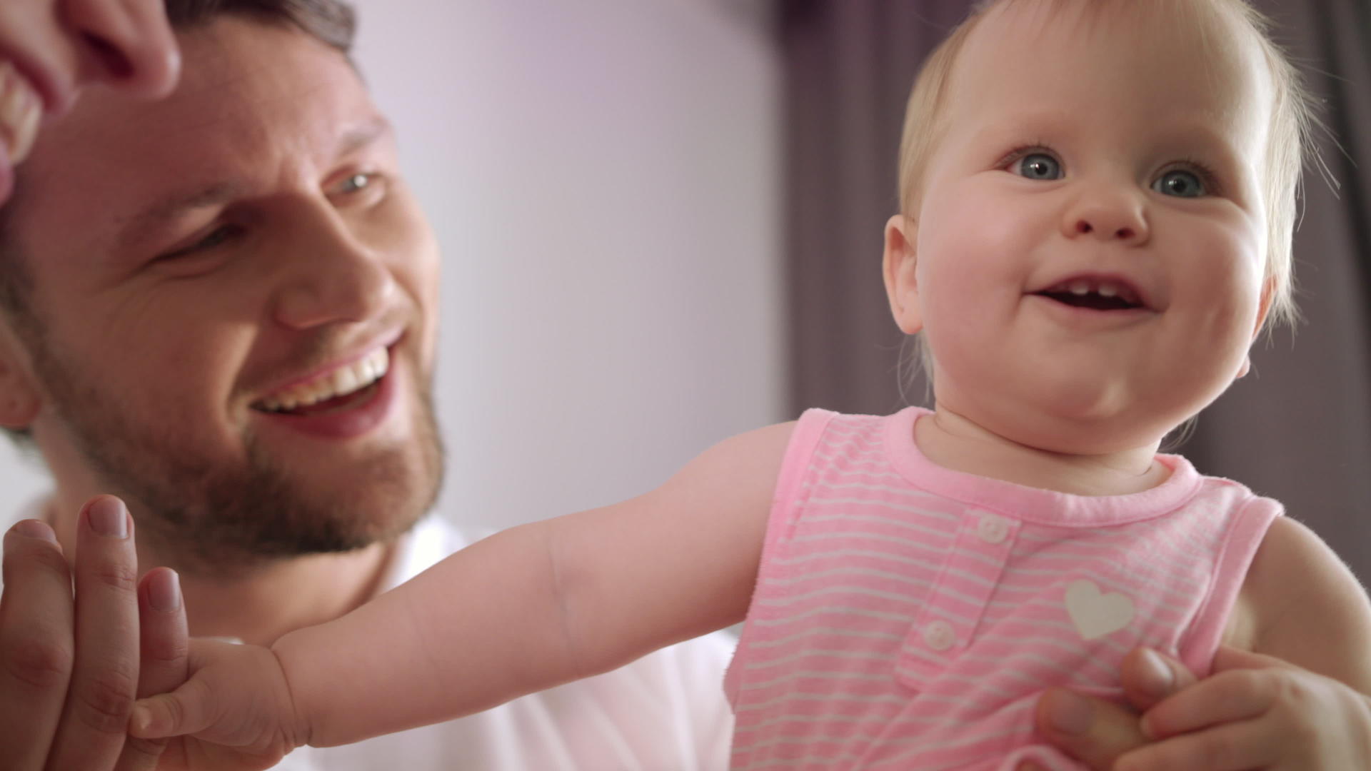 父亲拥抱可爱的女婴和父母玩耍的肖像视频的预览图