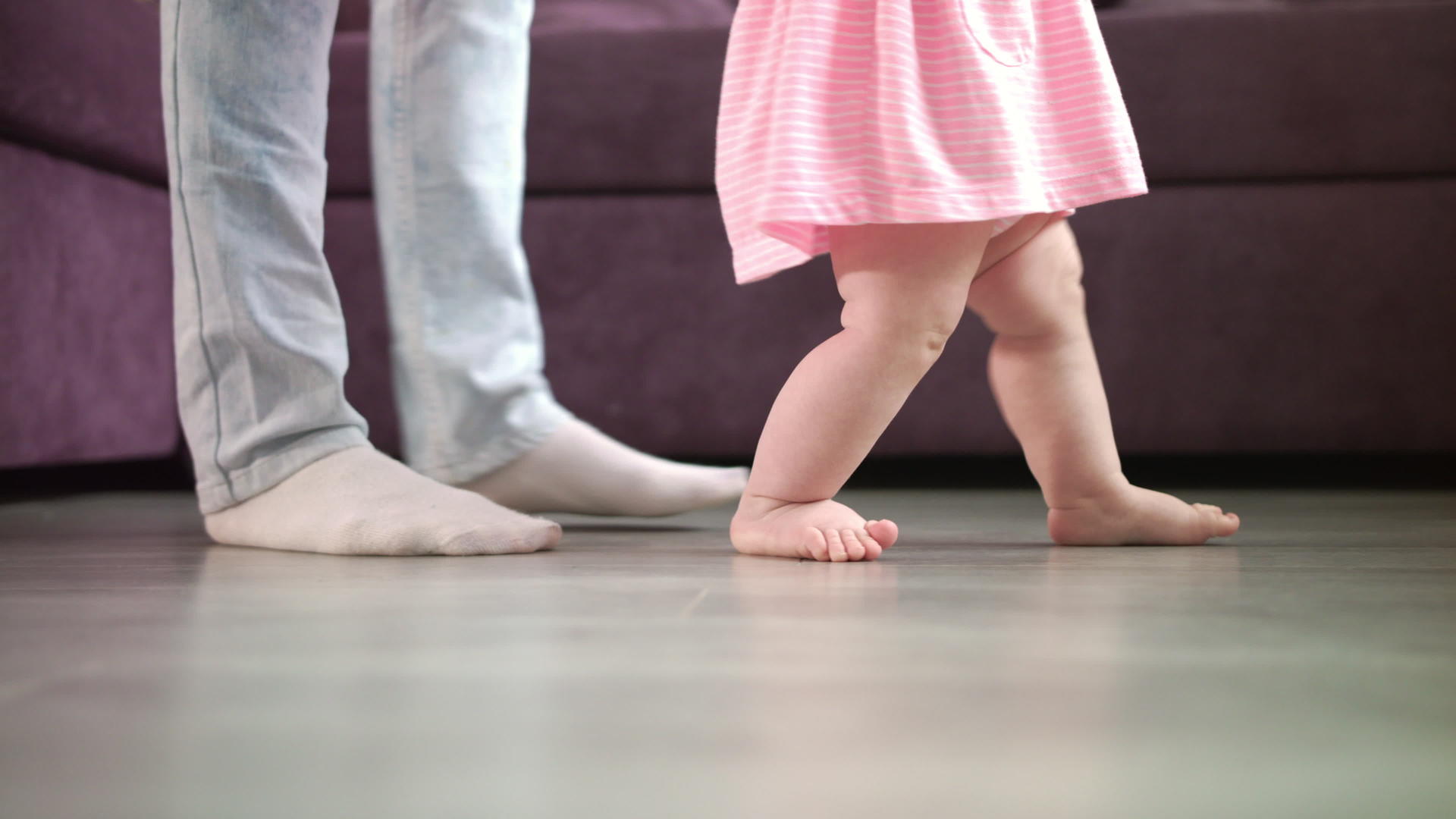 在父母的支持下婴儿脚在地板上行走视频的预览图