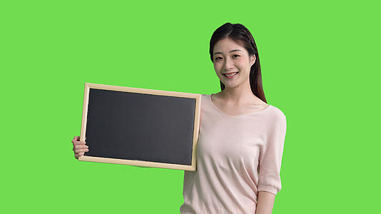 4k女生手拿黑板展示指示推荐绿幕抠像视频视频的预览图
