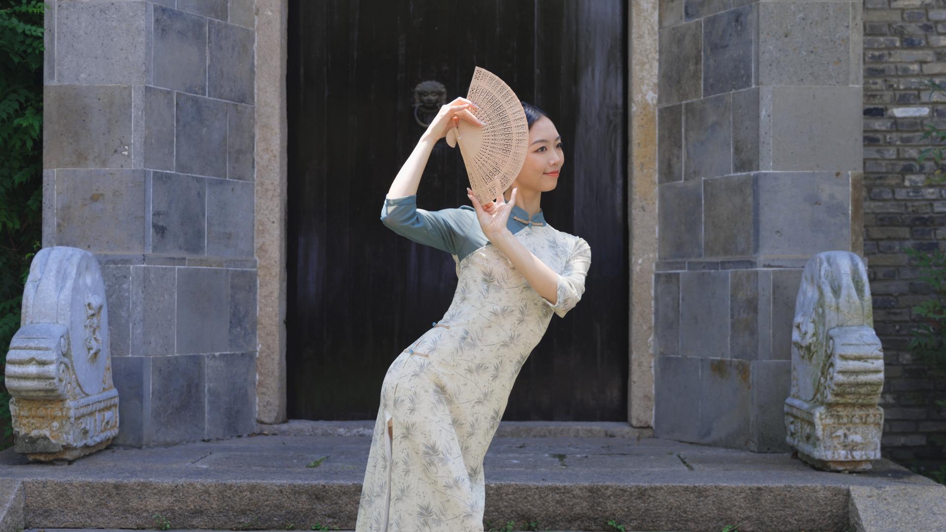 旗袍女生手持木扇舞动身躯视频的预览图