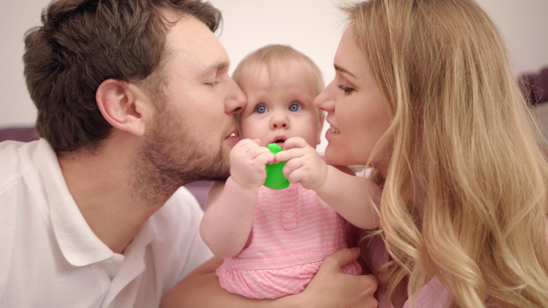 有孩子的美丽家庭甜蜜爱父母亲吻女婴视频的预览图