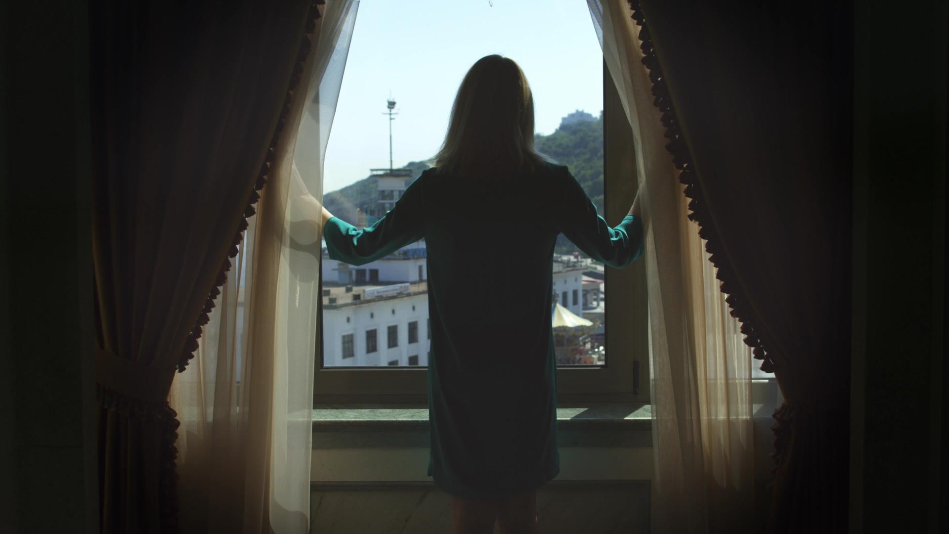 年轻女性到窗前打开窗帘后视线视频的预览图