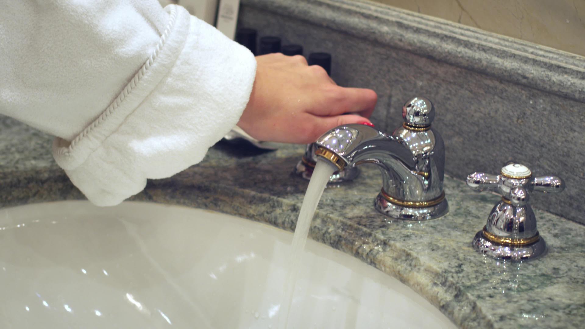 女人打开浴室水龙头用自来洗手视频的预览图