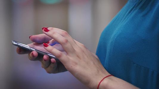在移动电话侧视线上用红色触摸屏幕的女性手视频的预览图