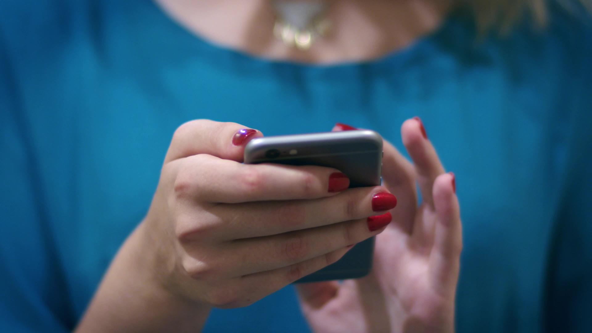 女性在屏幕智能手机上发送信息视频的预览图