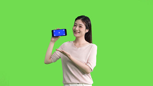 4k女生手拿手机横屏展示绿幕抠像视频视频的预览图