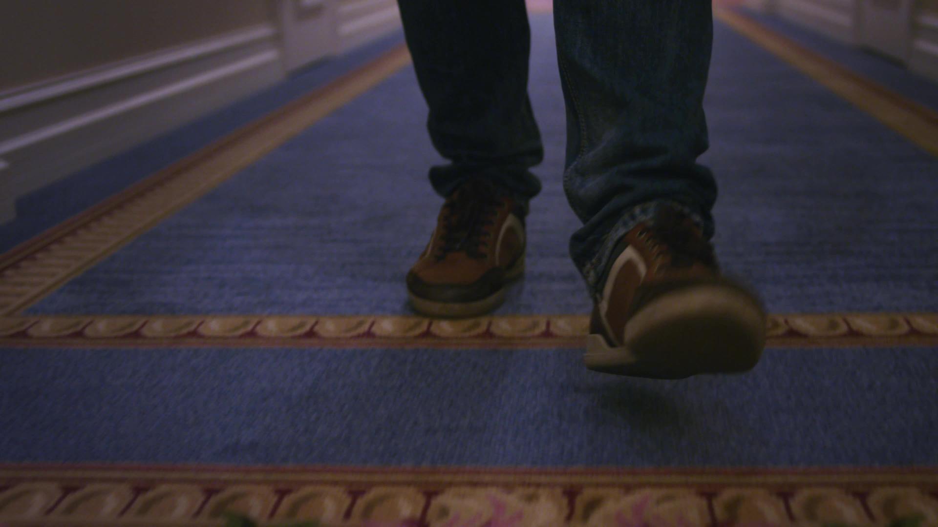 男人穿着棕色运动鞋走在蓝地毯上视频的预览图