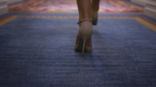 性感的女人穿着蜜蜂鞋走在地毯板后面视频的预览图