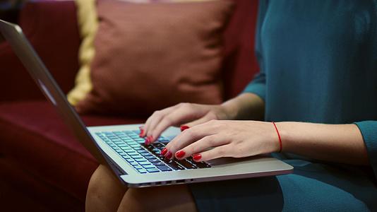 女笔记本电脑工作时女人的手在键盘上打字视频的预览图