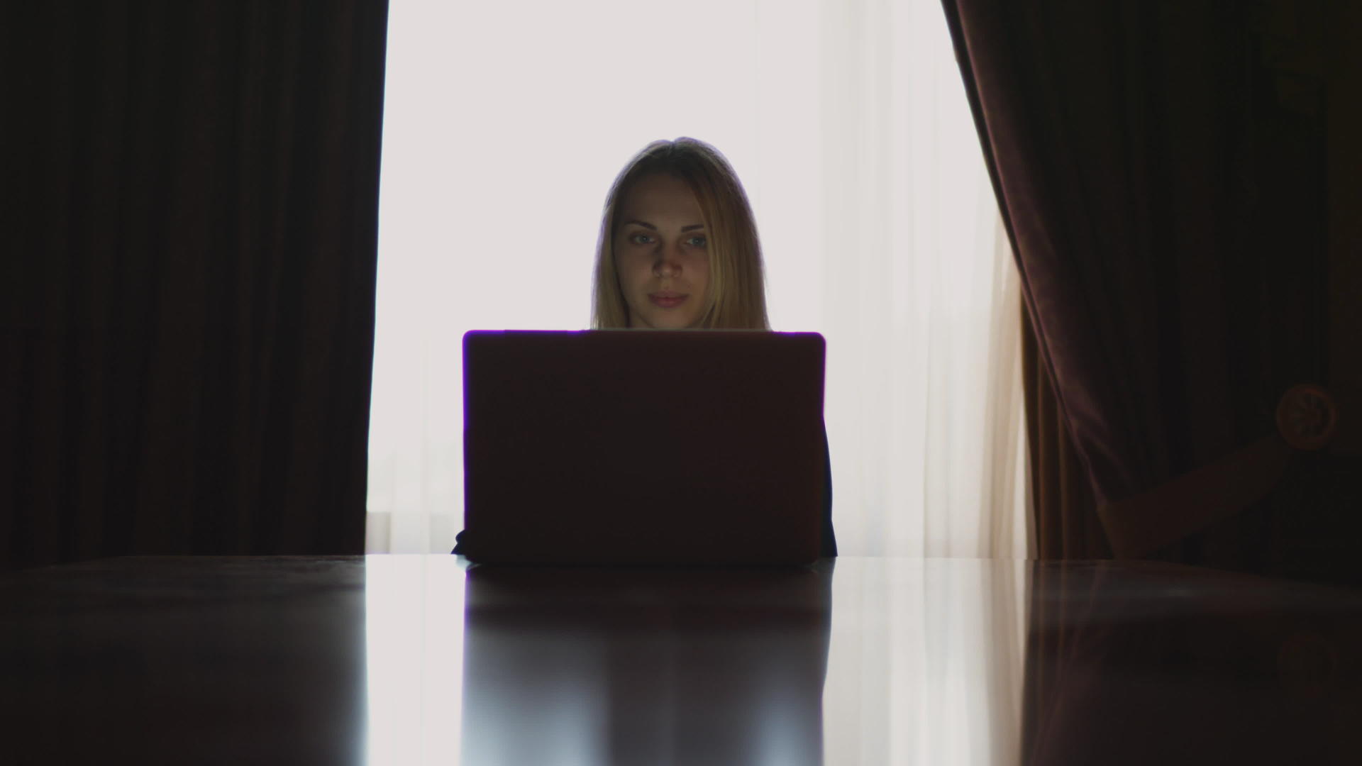打开笔记本电脑的年轻女性坐在桌子上视频的预览图