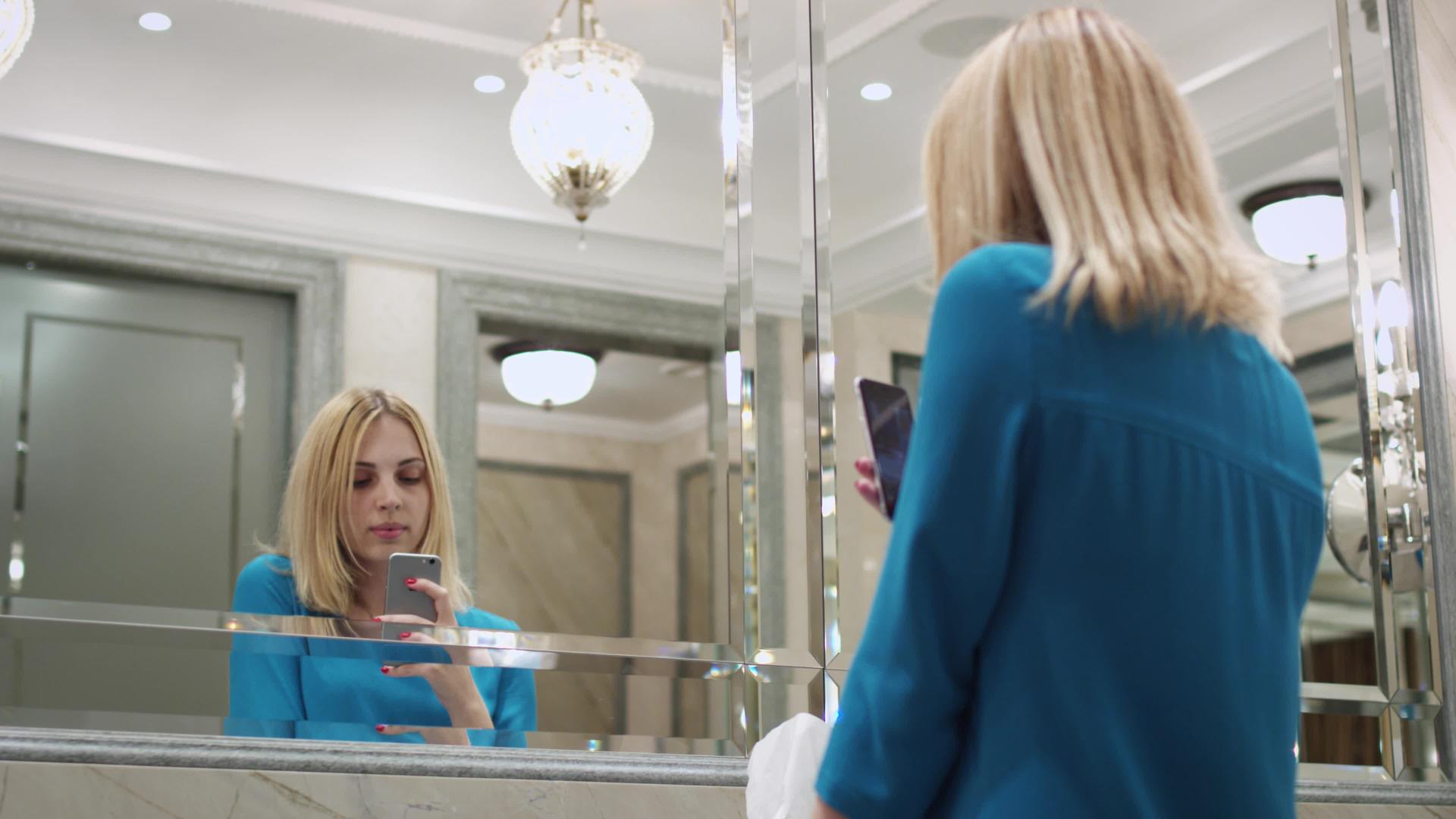 美女在浴室手机前镜上拍照视频的预览图