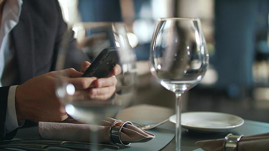 男人用手在餐桌上打男电话视频的预览图