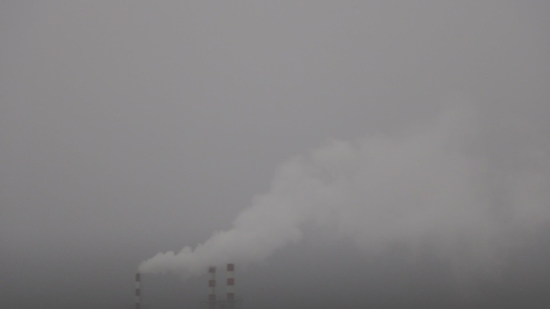 烟囱烟笼罩在灰色的天空中视频的预览图