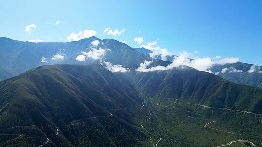 4K航拍蓝天白云高山蜿蜒小路美丽自然风光视频的预览图