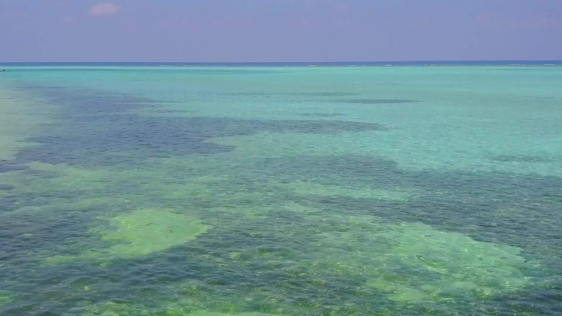 蓝色海平面在珊瑚礁附近有一个白色的沙子背景视频的预览图