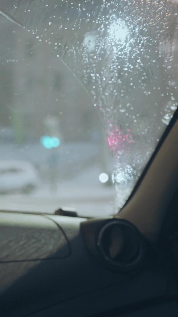 雨雪天气城市交通红绿灯路口等候车内视角视频的预览图