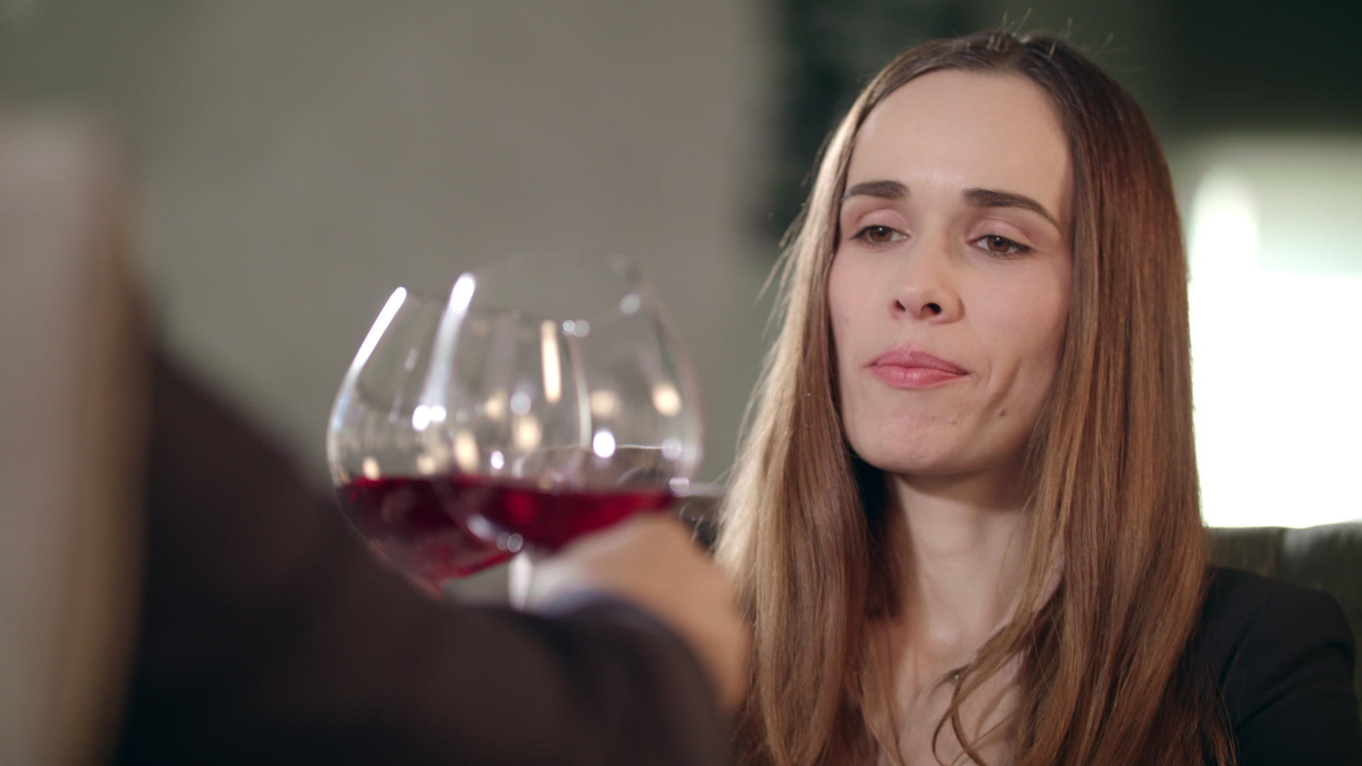 在餐厅里一个女人和一个男人碰杯喝红酒的女人视频的预览图