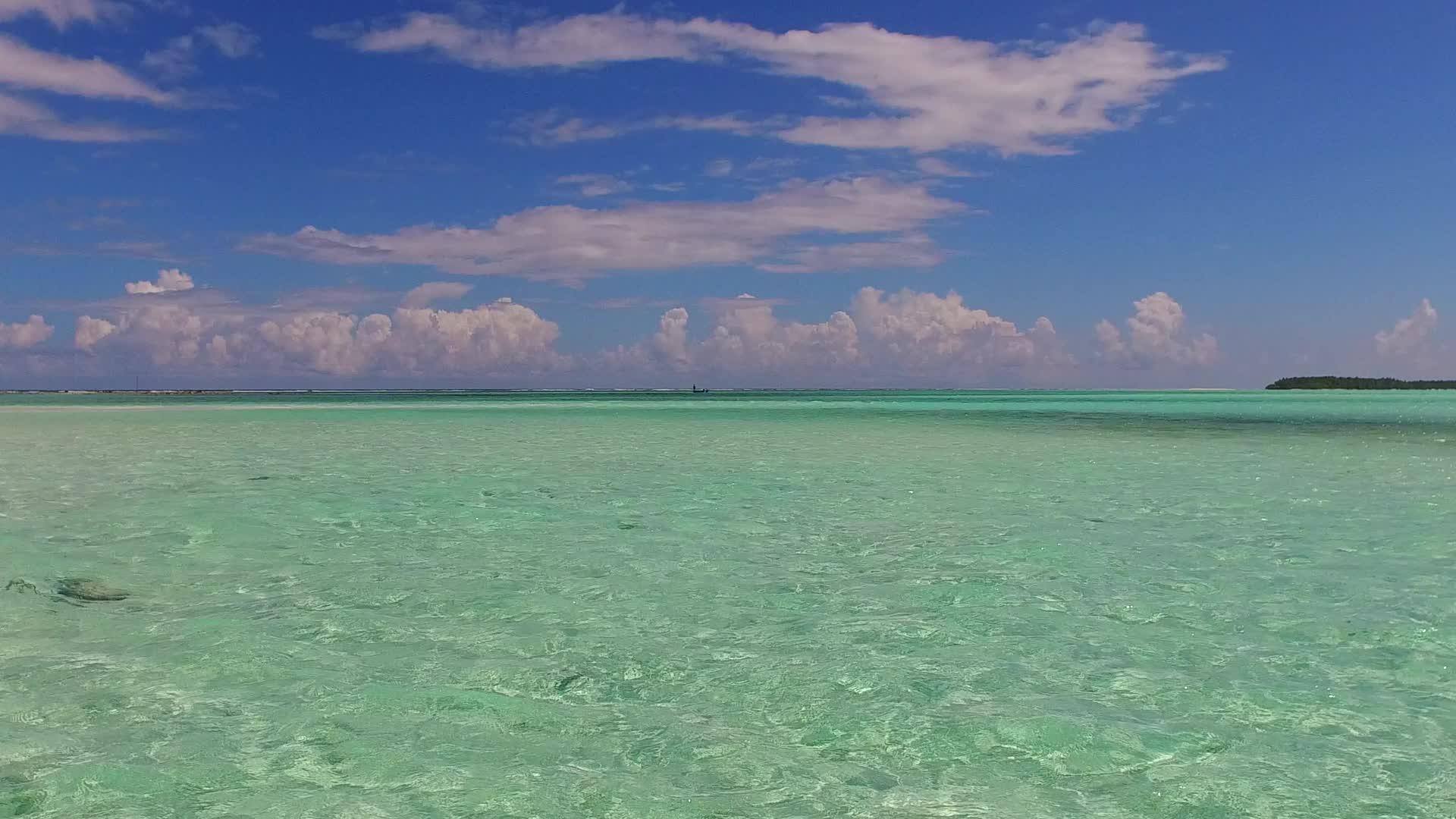 日出后穿过浅海和白沙的海湾海滩视频的预览图