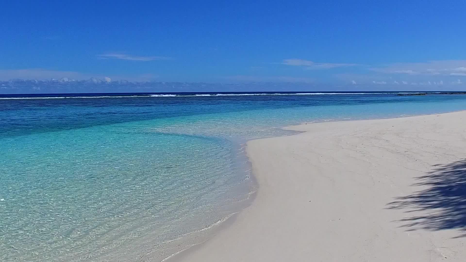 海滩附近的蓝色水域和白色沙滩背景下的白色沙滩凉爽的海滩开放景观视频的预览图