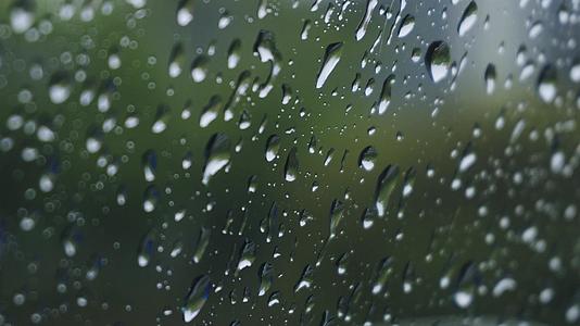 4K春雨意境下雨天雨水打在窗玻璃上雨滴特写视频的预览图