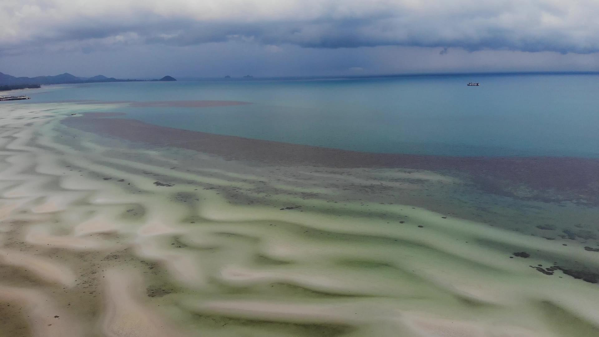 风雨如磐石的天空和不寻常的白色沙滩海岸在晴朗的日子里视频的预览图