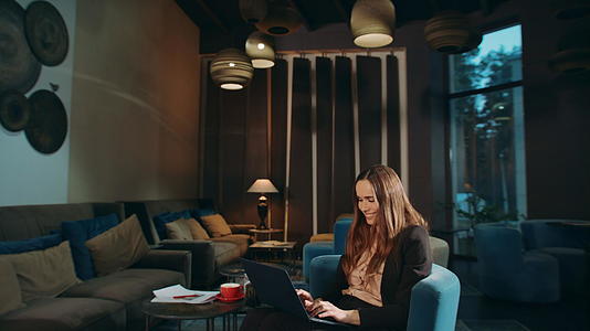 微笑女性在酒店使用笔记本电脑视频的预览图
