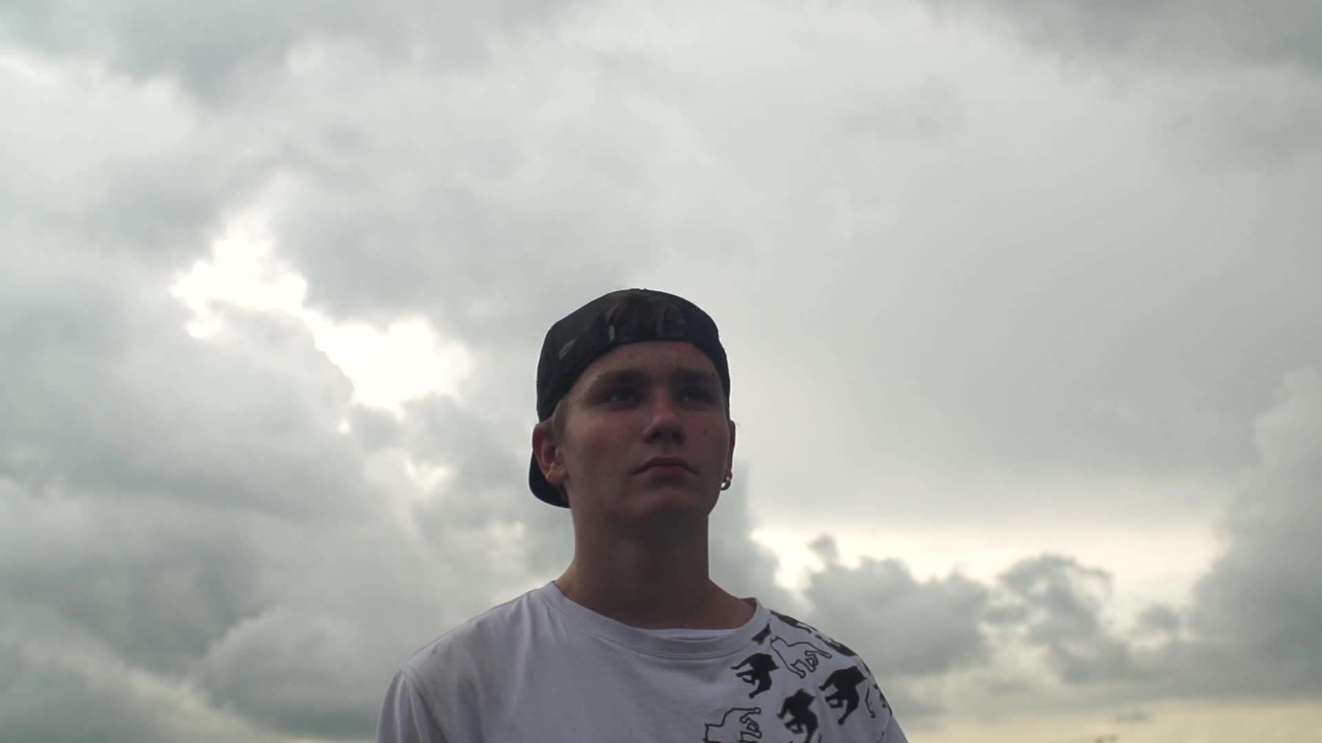 年轻人背对着多云的天空视频的预览图