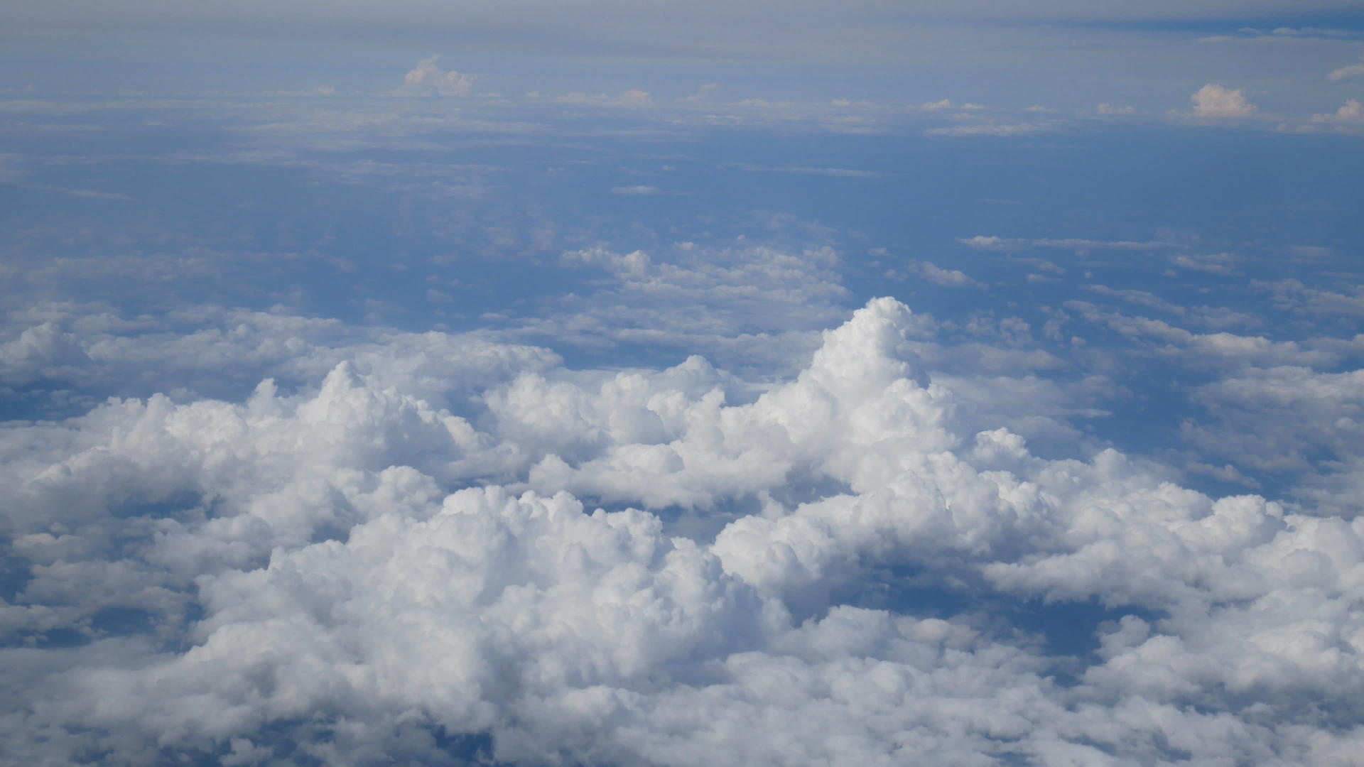 通过飞机窗口的鸟瞰图美丽的白云在蓝天的背景下飞行视频的预览图