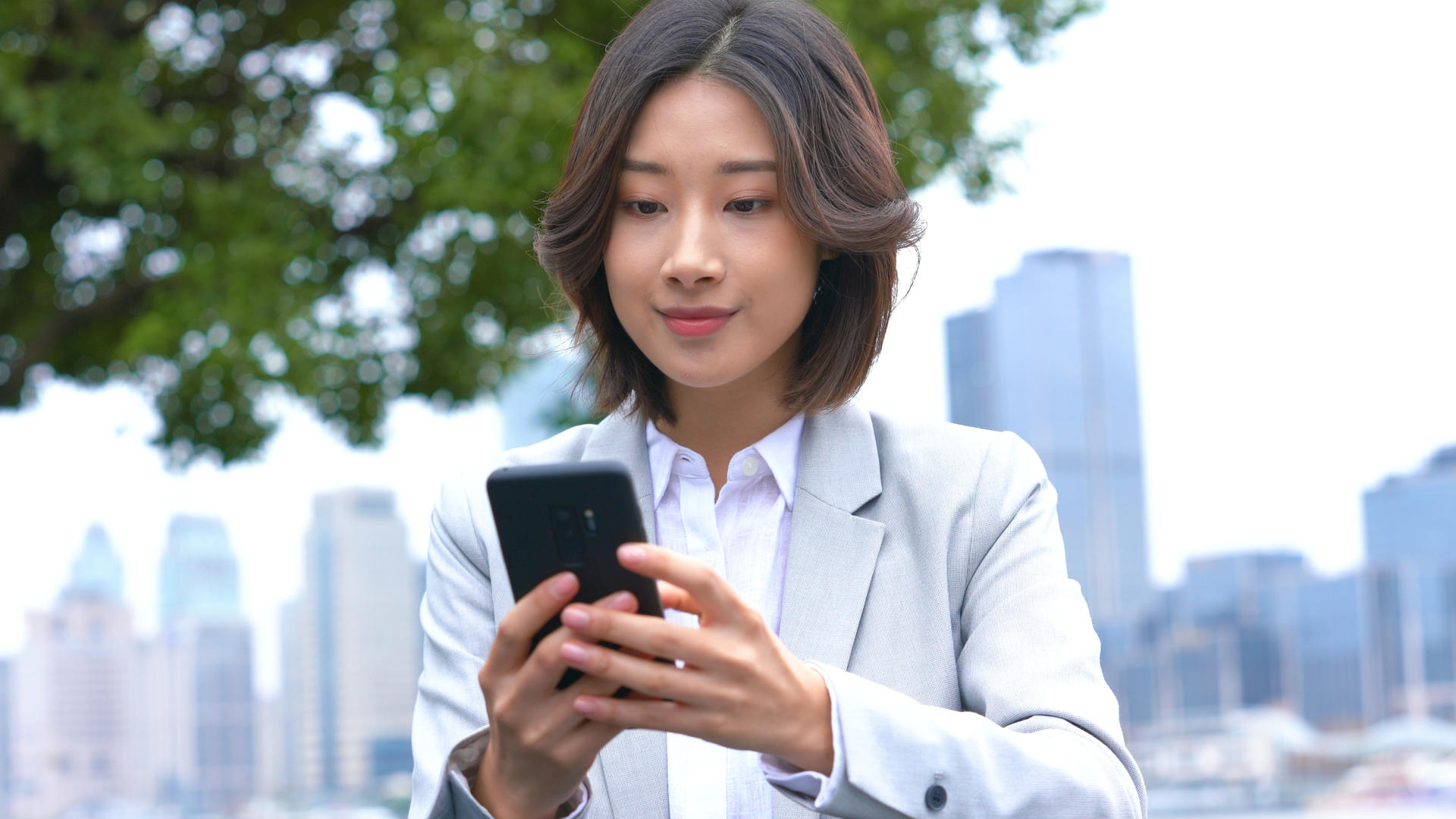 4k户外商务女性使用手机打字视频的预览图
