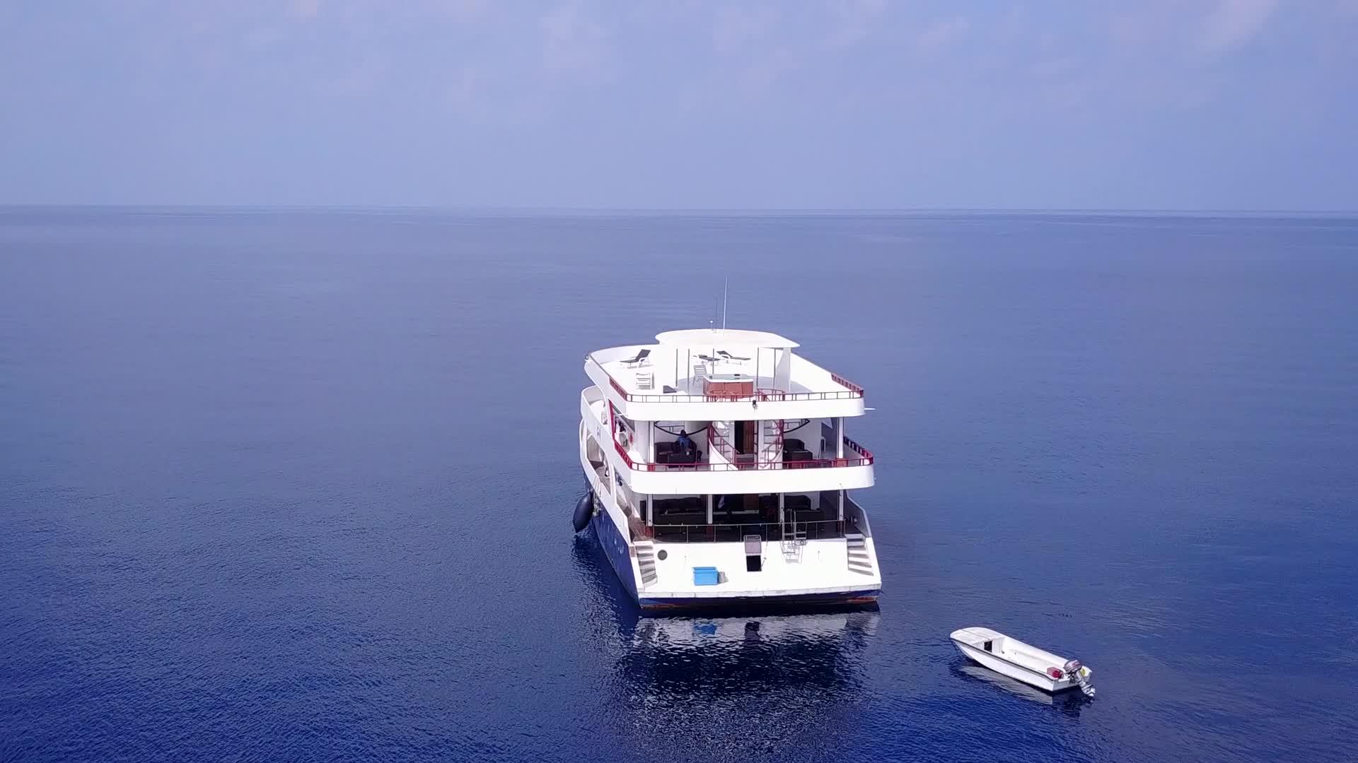 在蓝色水和白色沙底的背景下放松旅游海滩探索视频的预览图