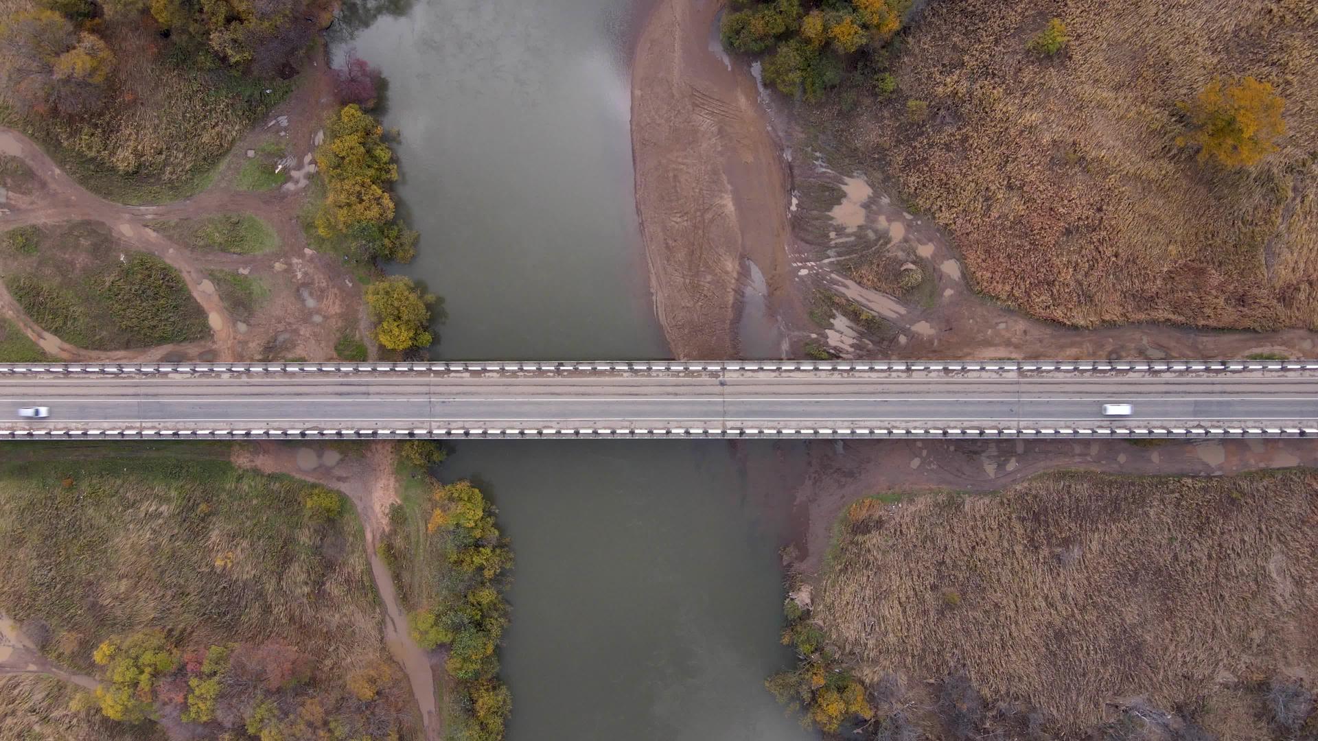 摄像机飞过一条小河上的公路桥平原景观视频的预览图
