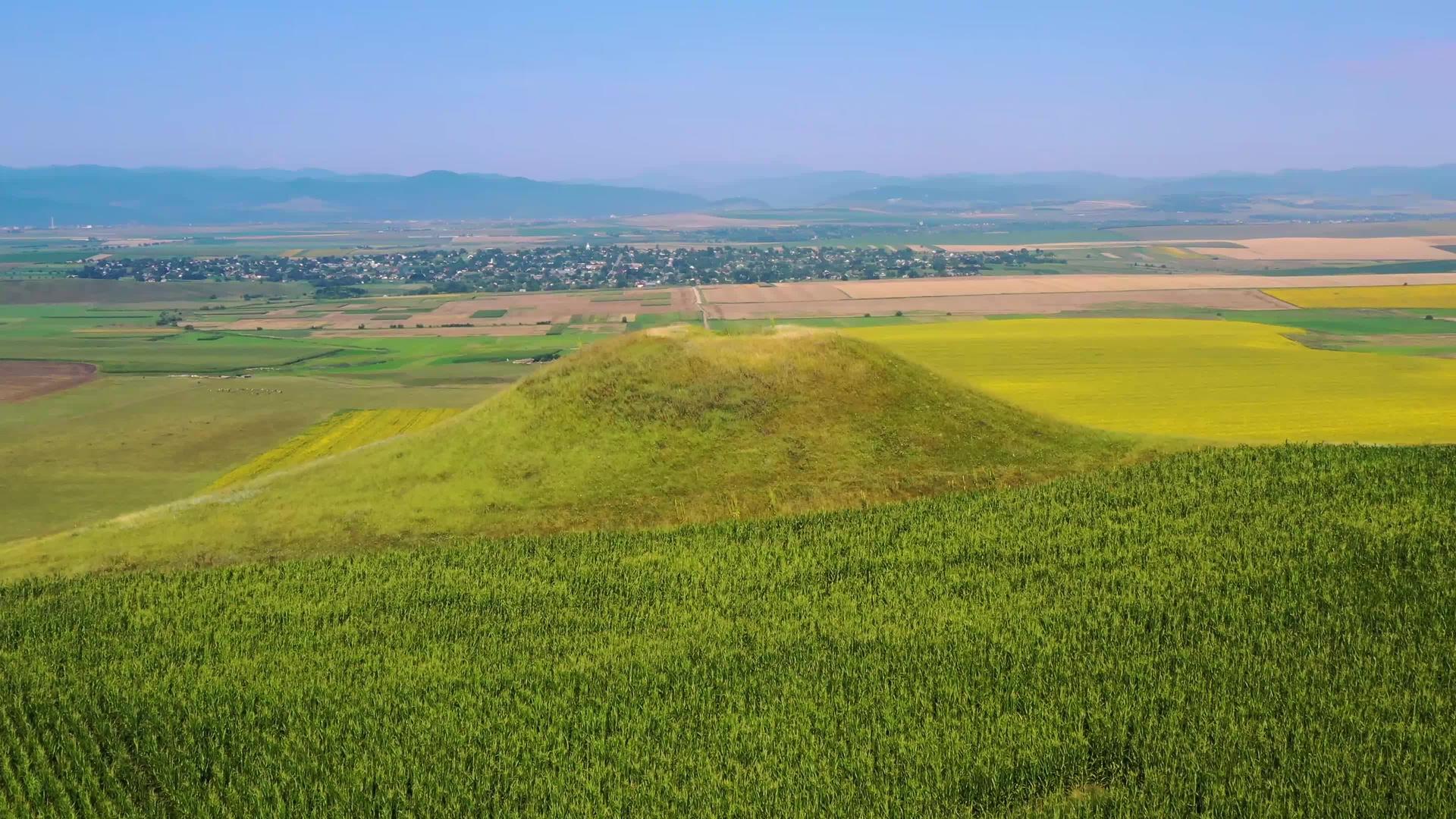 无人驾驶飞机在山上飞行在夏季的农村地貌和绿色的山脉视频的预览图
