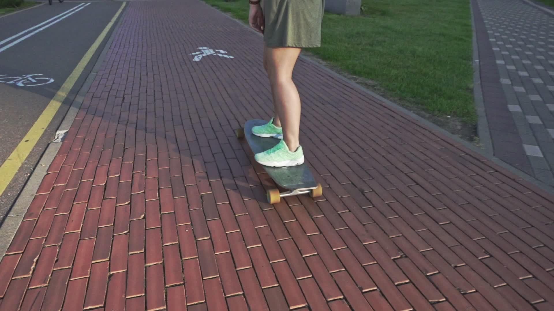 看着年轻女子骑着滑板慢动作在户外视频的预览图